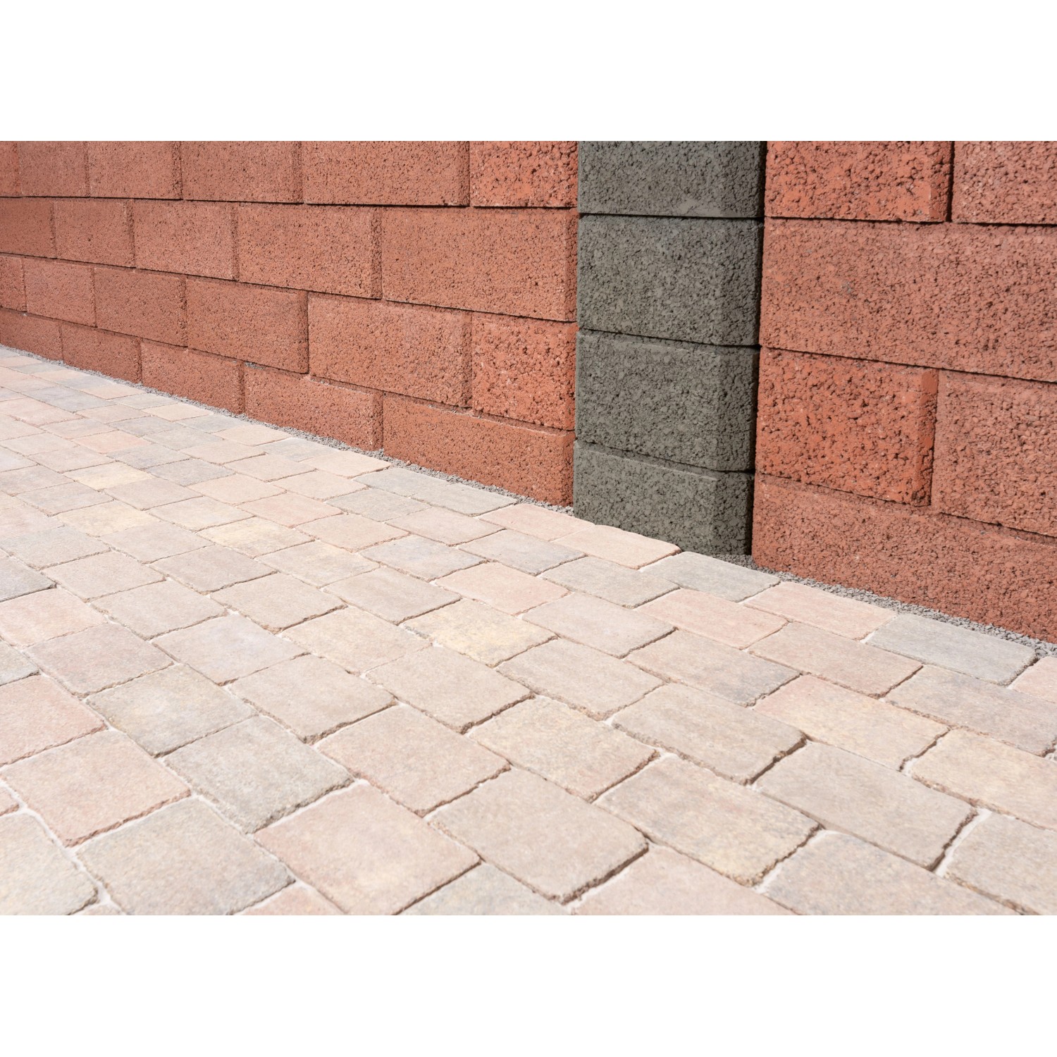 Verlegte Antik-Pflastersteine in Altstadtfarben, umrandet eine rote Mauer mit grauer Säule.