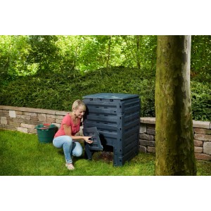 Schwarzer Garantia Komposter Eco-Master 450 l mit Frau bei der Entnahme im Garten.