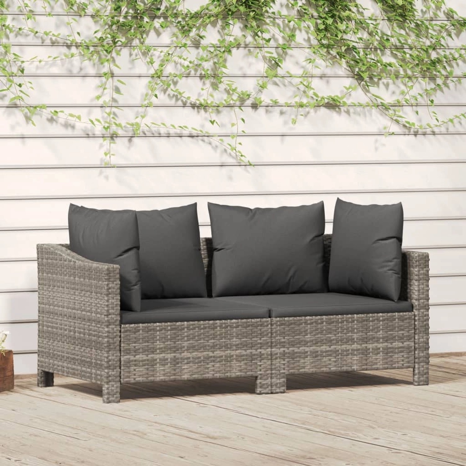 Graues 2-tlg. vidaXL Garten-Lounge-Set aus Rattan mit dunklen Kissen vor weißer Wand.