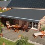 Graue Gelenkarmmarkise Star Fix 400x300 cm über Terrasse mit Gartenmöbeln.