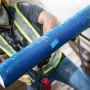 Bosch Expert Säbelsägeblatt S 1750 RD schneidet blaues Zementrohr, Arbeiter im Hintergrund.