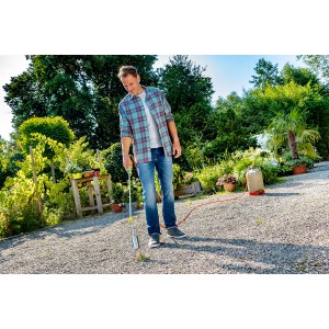 Mann benutzt Gloria Unkrautbrenner Thermoflamm bio Professional Plus mit Schlauch im Garten.