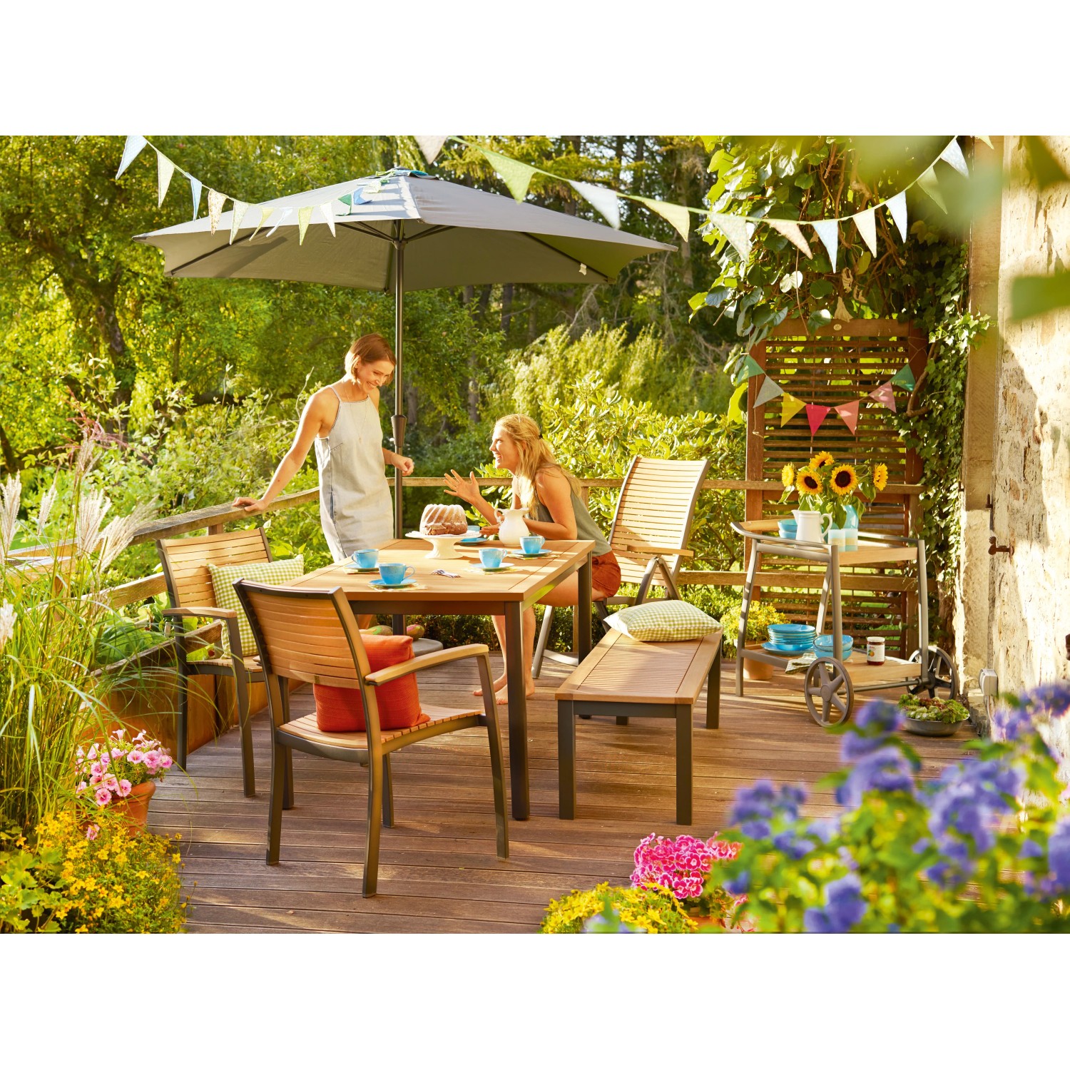 Gartenszene mit Holz Stapelstuhl Bonlee und Gartentisch auf einer Terrasse.