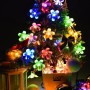 Bunte Salcar Solar-Lichterkette mit 20 Kirschblüten-LEDs, dekoriert eine Pflanze für stimmungsvolle Weihnachtsbeleuchtung.