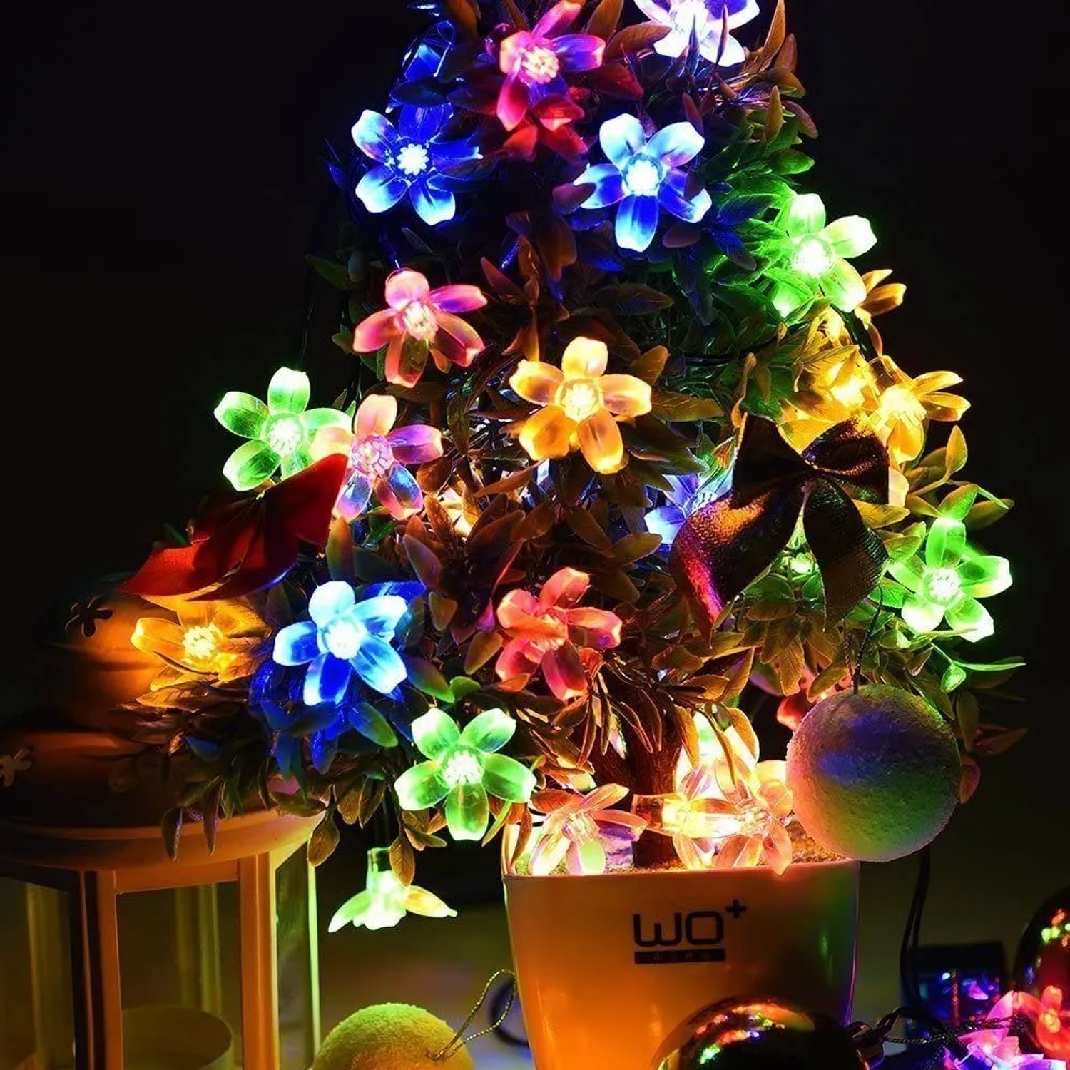 Bunte Salcar Solar-Lichterkette mit 20 Kirschblüten-LEDs, dekoriert eine Pflanze für stimmungsvolle Weihnachtsbeleuchtung.