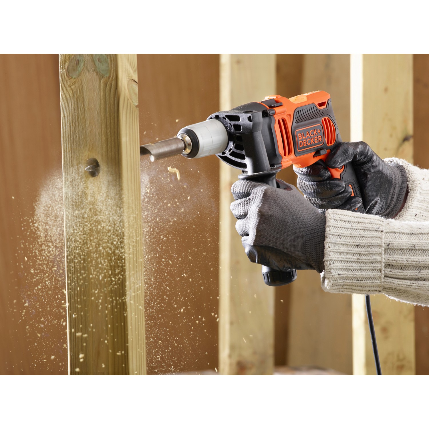 Black+Decker Schlagbohrmaschine BEH850K beim Bohren in Holz, inklusive Koffer.