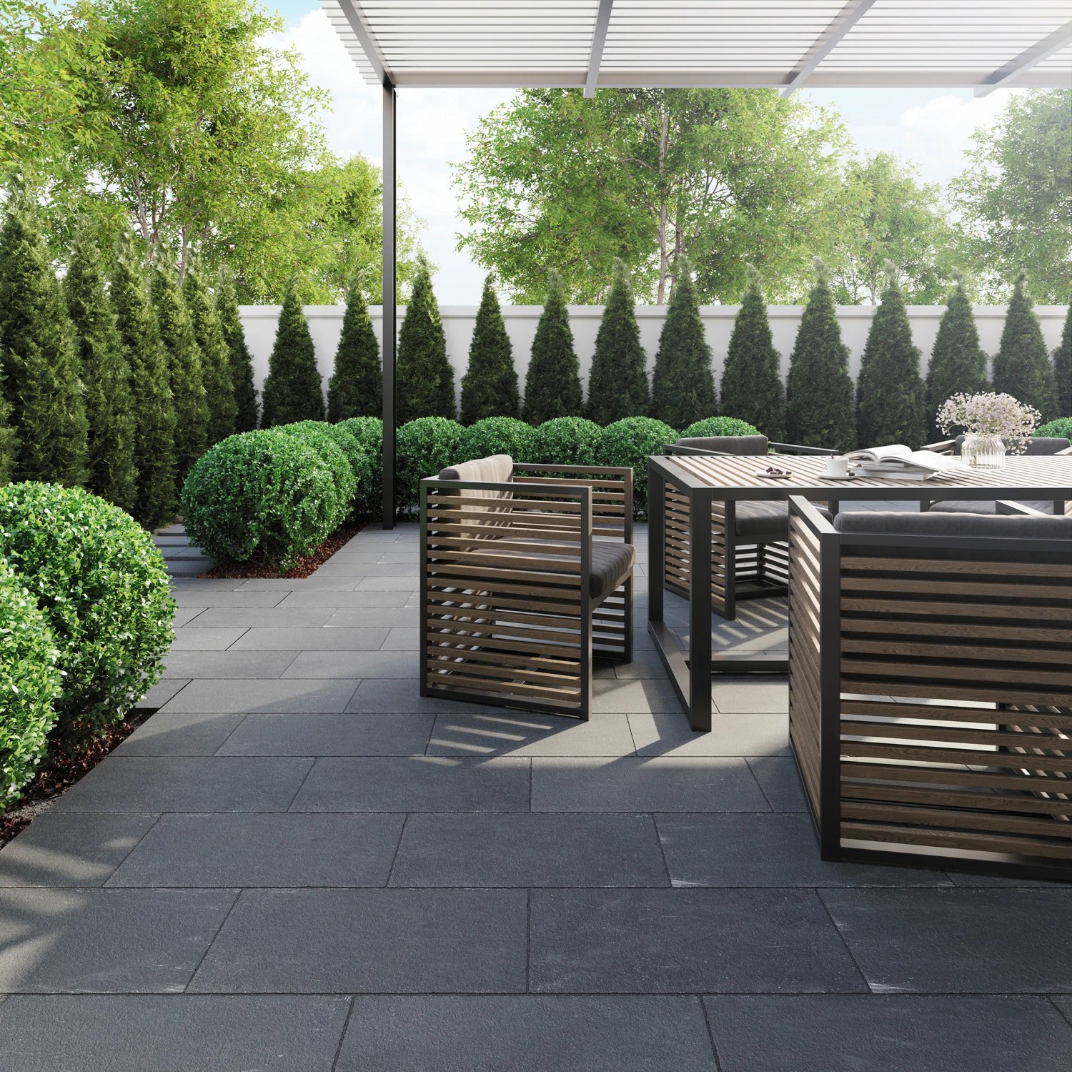 Terrasse mit dunklen Natursteinplatten Lima Black (30x60). Gartenmöbel und grüne Bepflanzung.