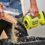 Ryobi Akku-Handsauger RHV18 beim Entleeren des Behälters in einen Müllsack.