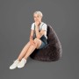 Frau sitzt im anthrazitfarbenen Sitting Point Sitzsack Fluffy 220 l. Bequemer Sessel für Wohnzimmer.