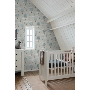 Dekorative Tapete mit blauen Luftballons und Wolken im Kinderzimmer. Weißes Babybett und Kommode.