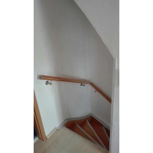 Handlauf aus Holz mit runden V2A Edelstahl Konsolen an einer Treppe.