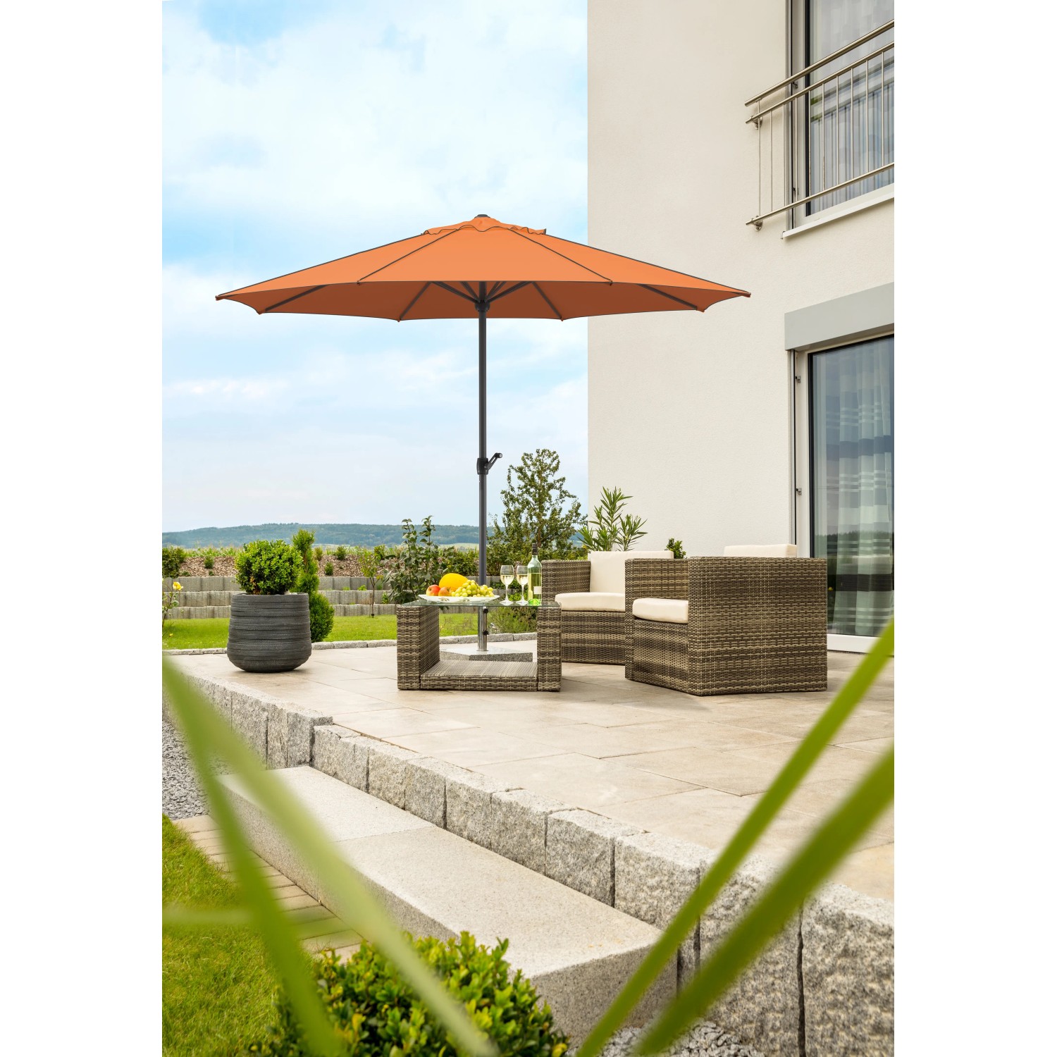 Terracottafarbener Schneider Marktschirm Adria Ø 350 cm mit Kurbel auf Terrasse.