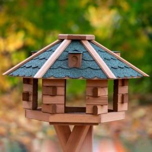 Sechseckiges Dobar Vogelhaus Blockhaus aus braunem Kiefernholz mit grünem Bitumendach.
