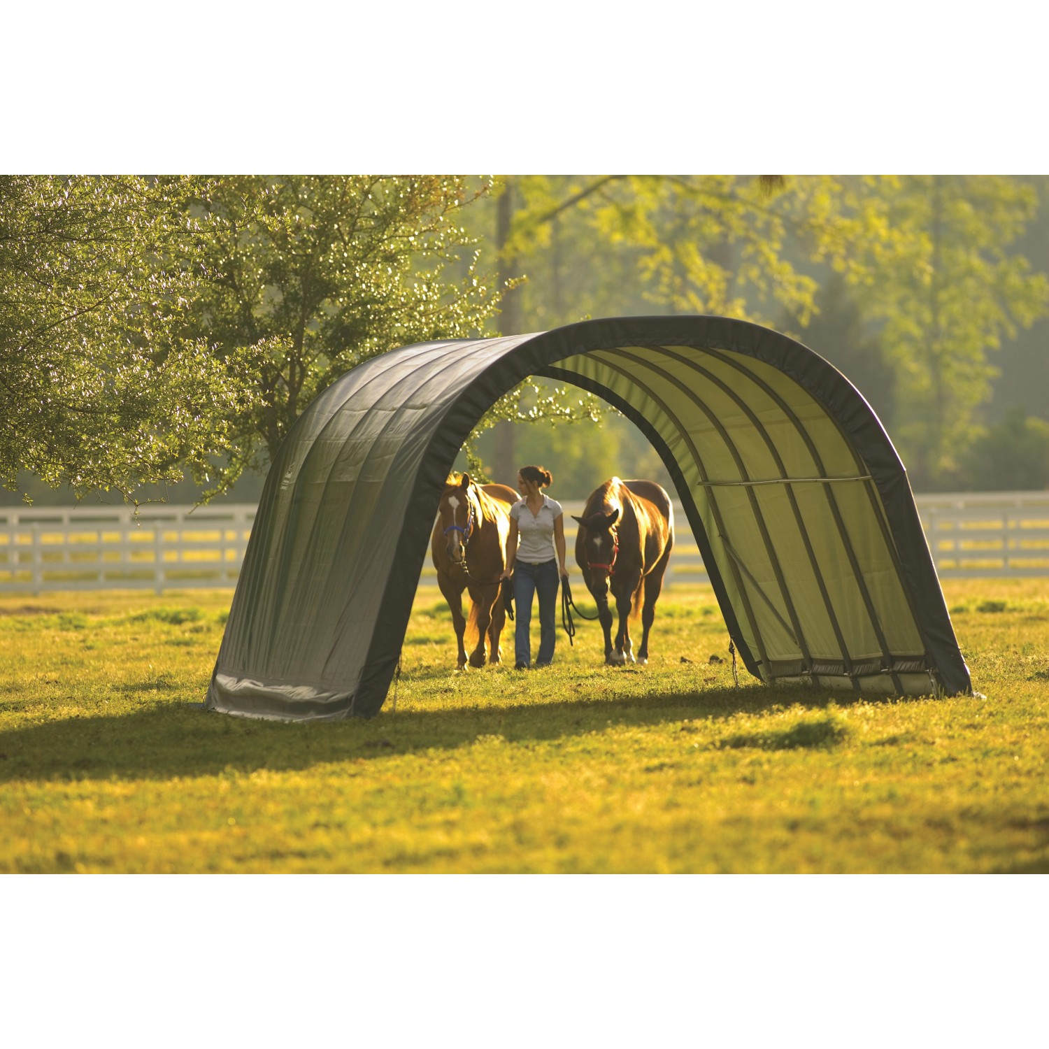 Weidezelt ShelterLogic Run-In-Shed mit zwei Pferden und einer Person auf einer Wiese.