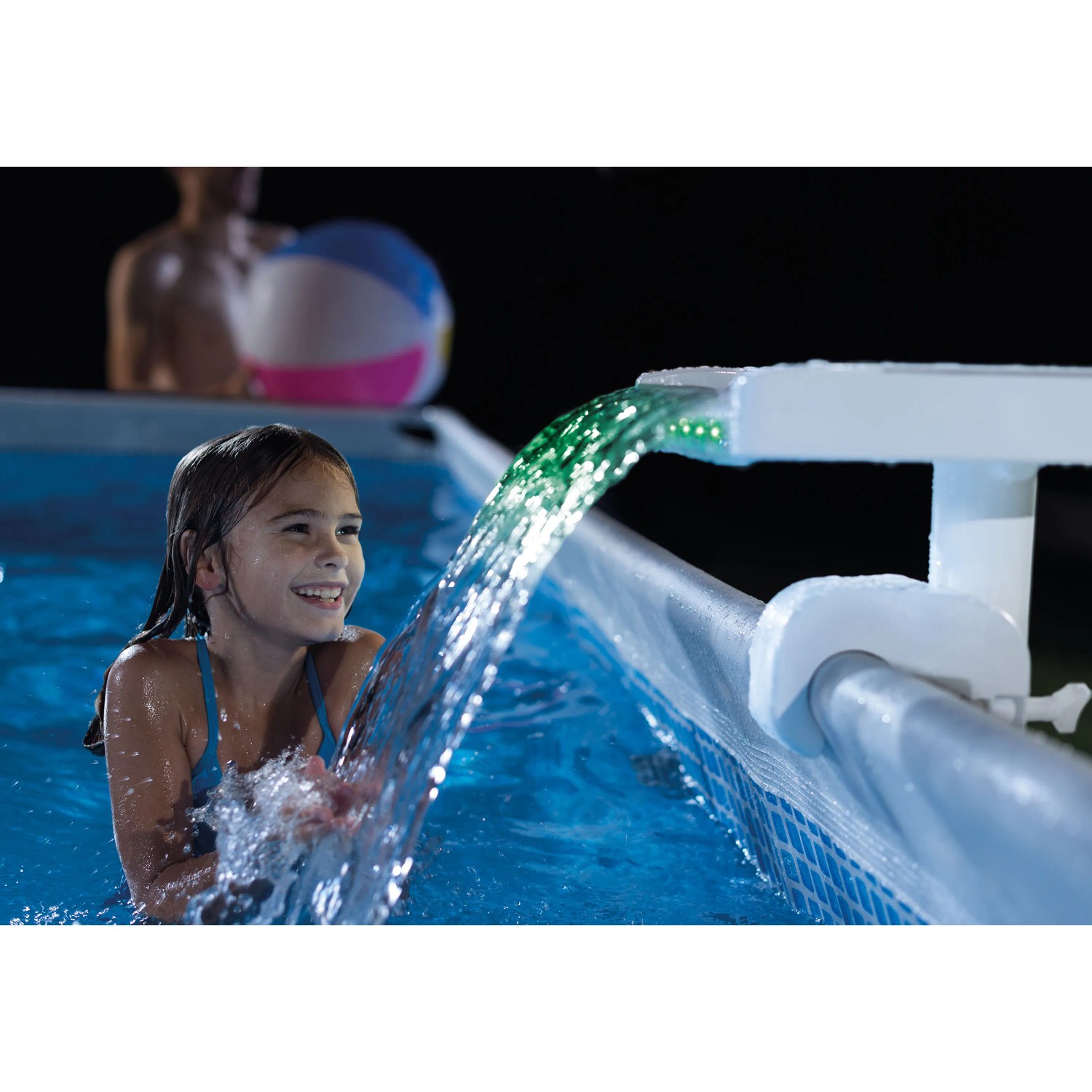 Intex LED Wasserfall Cascadee am Pool mit grün leuchtendem Wasser und spielendem Kind.