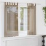 Zwei hellbraune Voile Vorhänge mit Schlaufen am Fenster. Semi-transparente Polyester-Gardinen für helle Wohnräume.