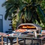 Ooni Koda 16 Gas Pizzaofen mit Pizza auf Pizzaschieber vor dem Ofen.