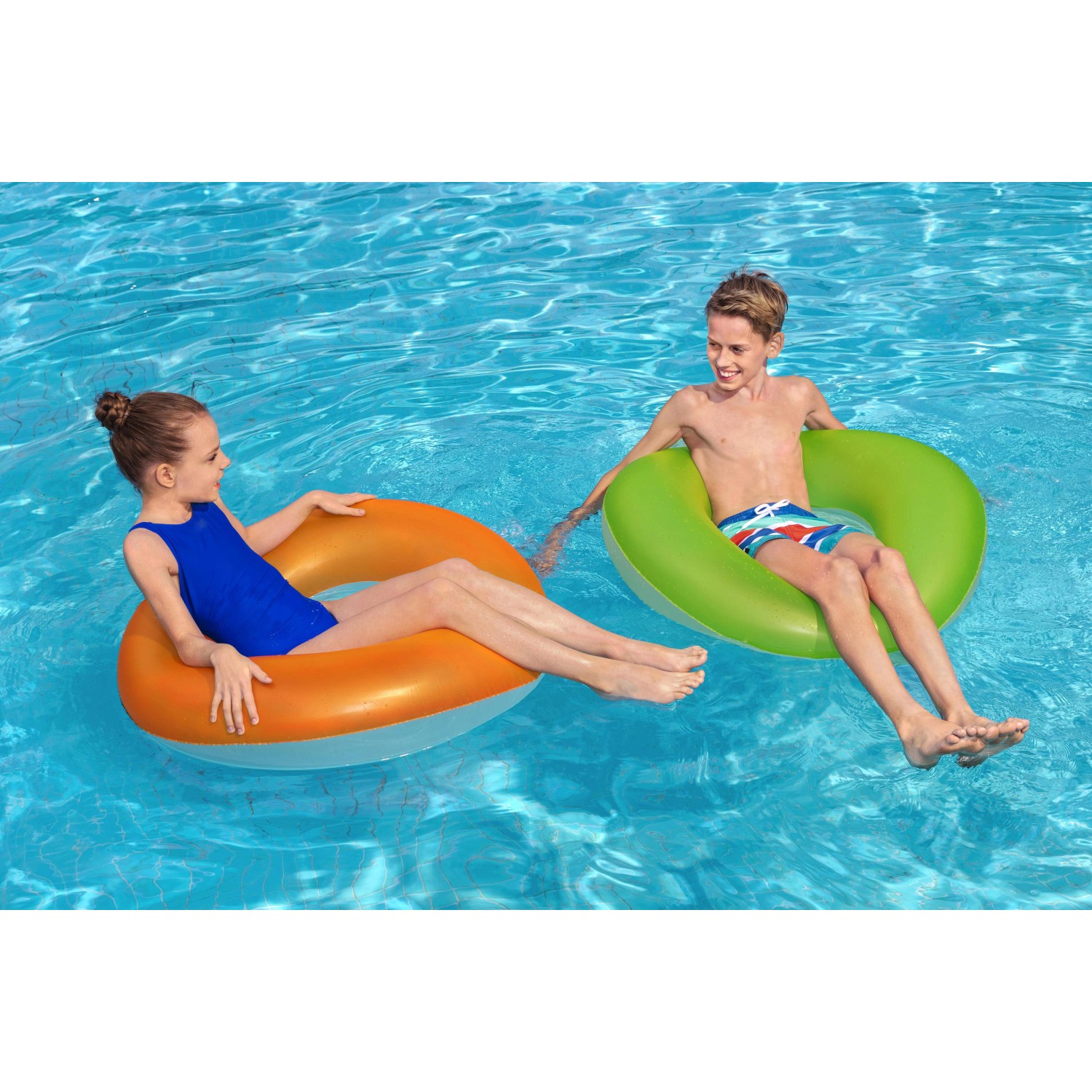 Zwei Kinder mit Bestway Schwimmringen (orange, grün) im Pool. Ø 91 cm.