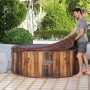 LAY-Z-SPA Helsinki AirJet Whirlpool mit Abdeckung und Mann im Garten.