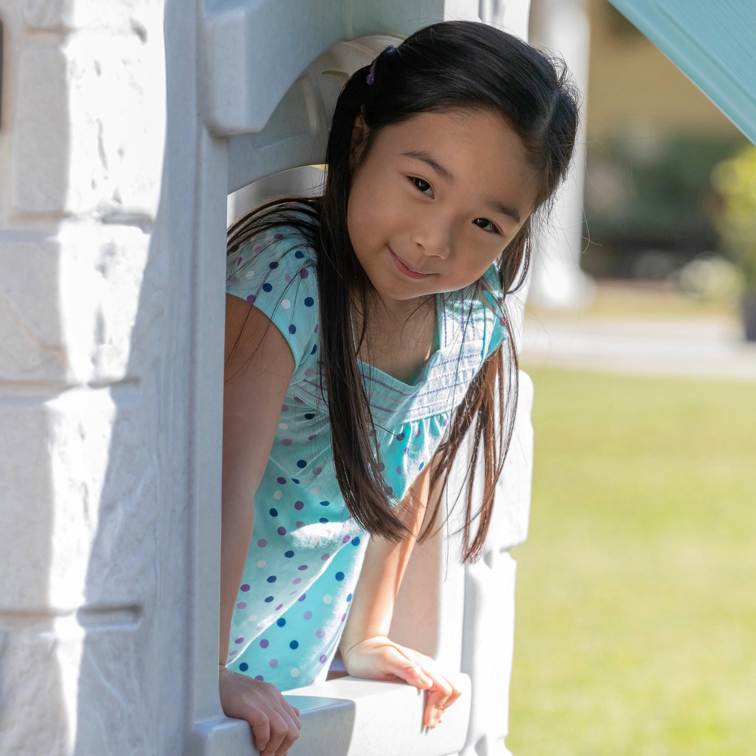 Mädchen schaut aus dem Fenster des Step2 Spielhaus Adventures 2-Etagen.