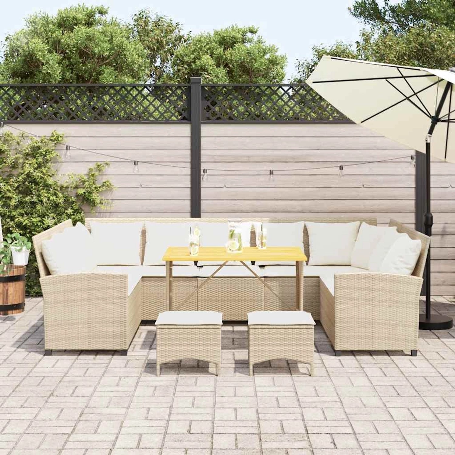 Beige 4-tlg. Garten-Sofagarnitur aus Rattan mit Tisch und Hockern, inklusive Kissen.