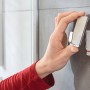 Hand befestigt Tesa Powerstrips Haken Waterproof Edelstahl an Fliese im Bad.