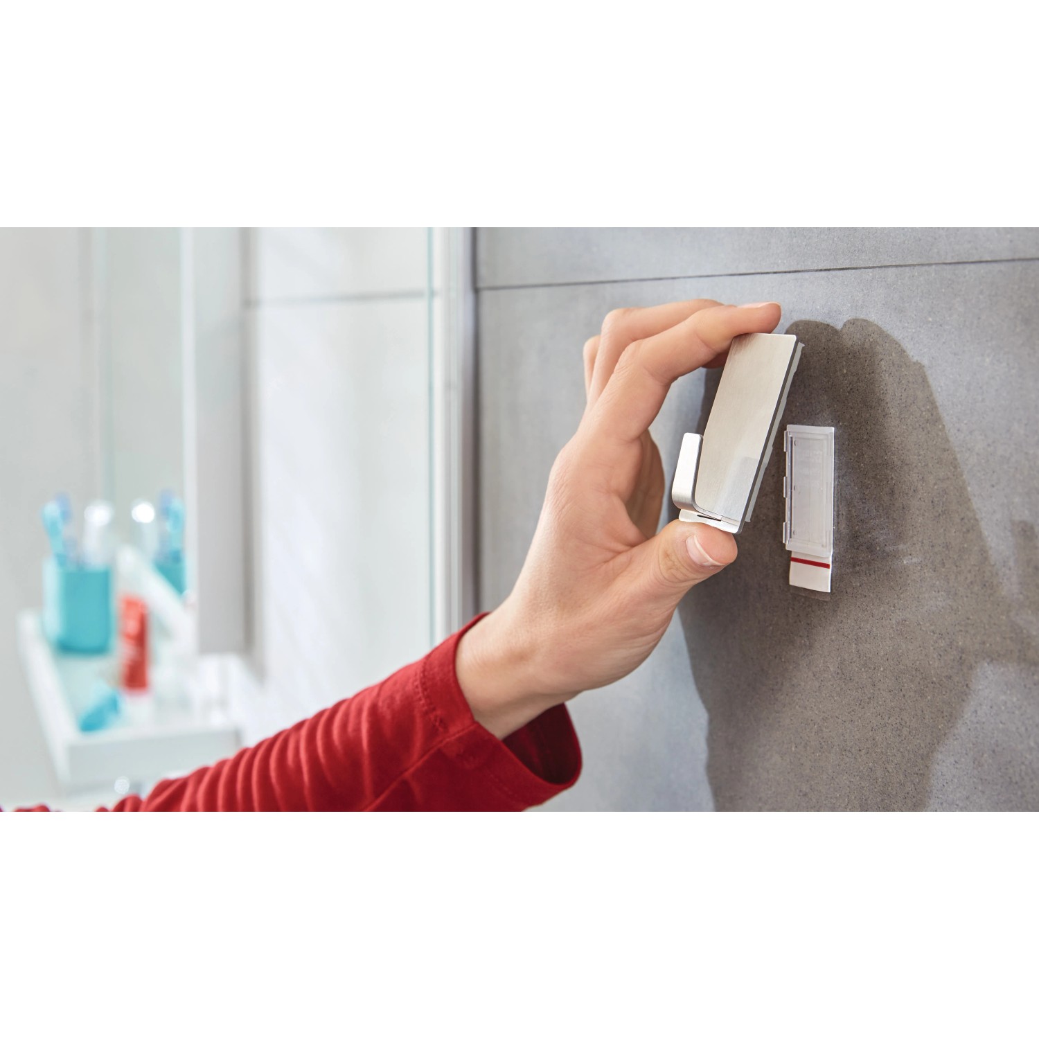 Hand befestigt Tesa Powerstrips Haken Waterproof Edelstahl an Fliese im Bad.