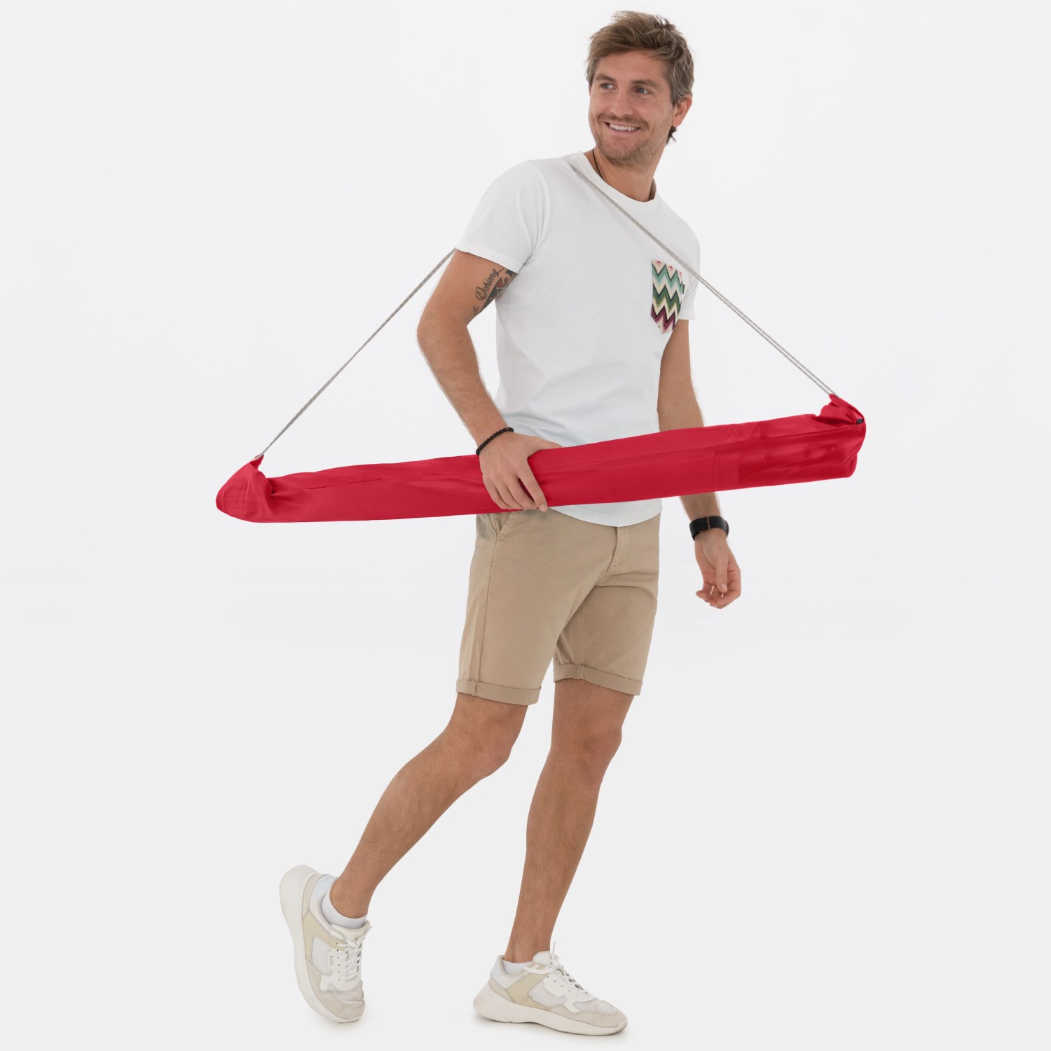 Mann trägt roten Doppler Strandschirm Windprofi Neo 200 über der Schulter.