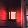 Philips Hue Impress LED-Wandleuchte breit, schwarzes Gehäuse mit rotem Lichtschein an Hauswand.