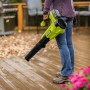 Ryobi Akku-Laubgebläse RY18BLA-140 One+ 18V mit Akku und Ladegerät im Einsatz auf einer Holzterrasse.