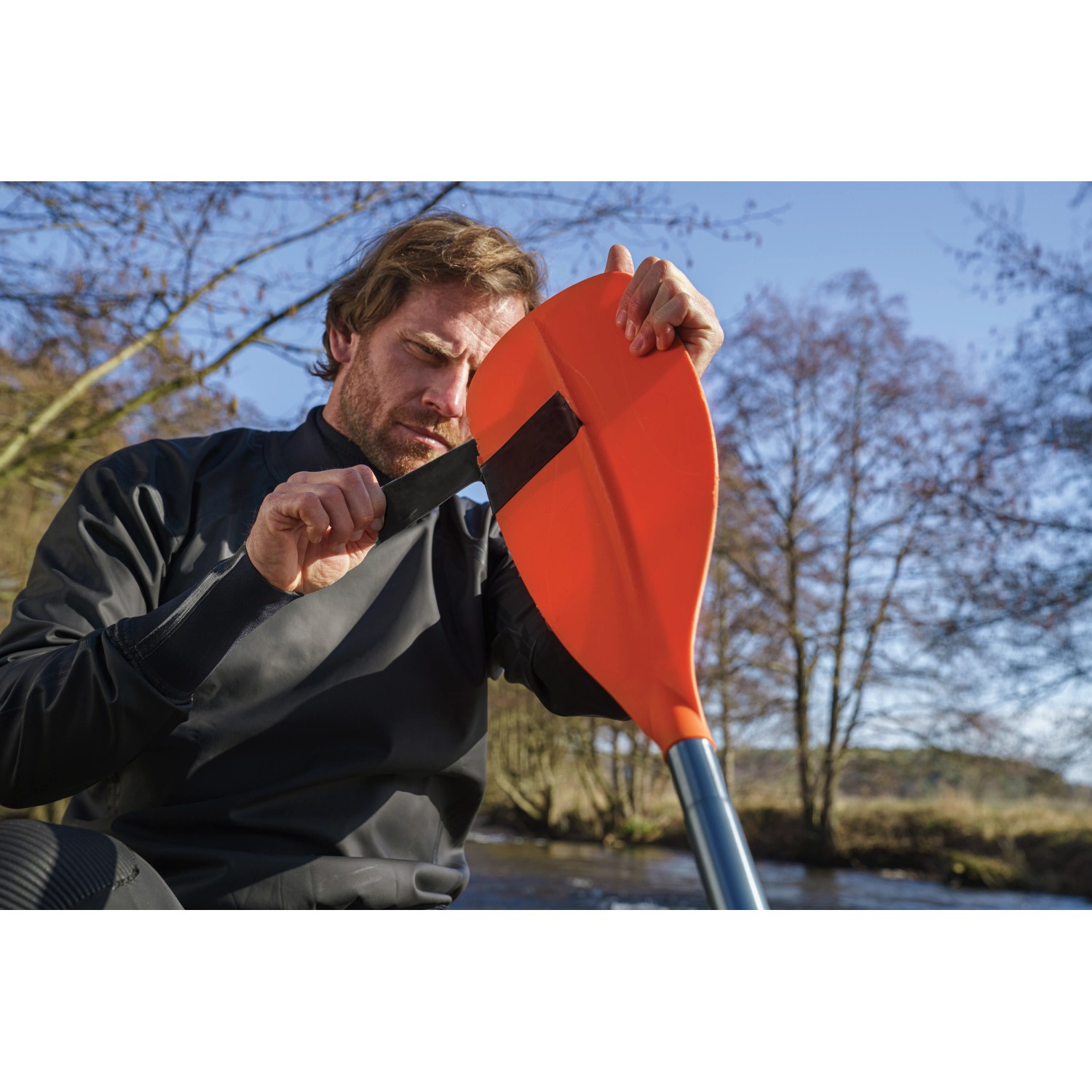 Mann repariert Paddel mit Tesa Reparaturband Ultra Power Under Water.