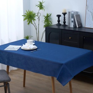 Blaue Vlies-Tischdecke auf Holztisch, gedeckt mit Geschirr. Ideal für Feste und Dekoration.