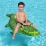 Kind auf grünem Bestway Schwimmtier Krokodil im Pool.