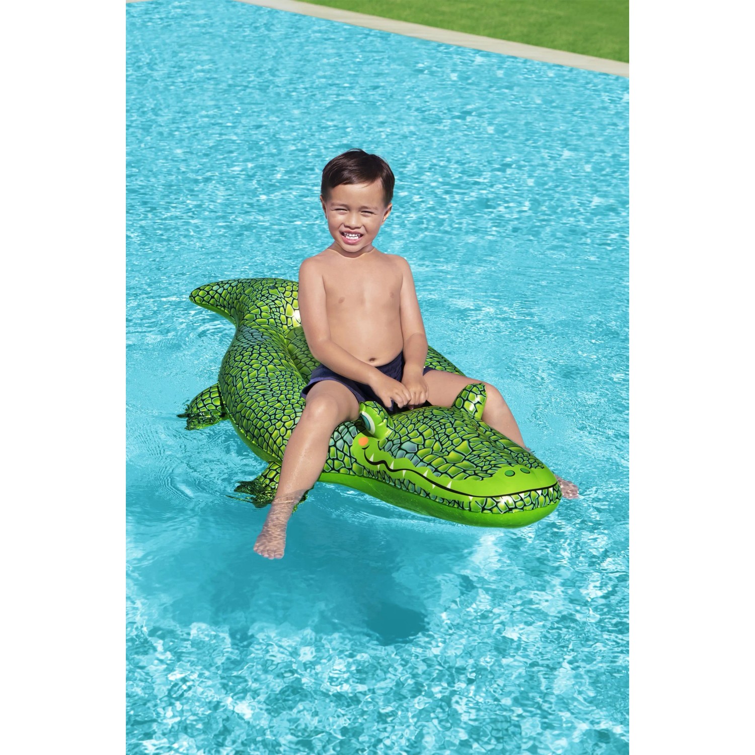 Kind auf grünem Bestway Schwimmtier Krokodil im Pool.