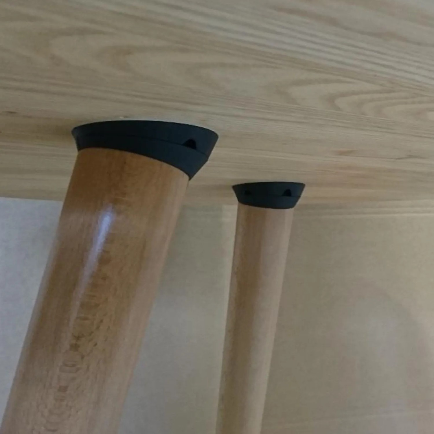 SOTECH TWIST'N TURN Tischbeinbeschlag, schwarz, mit schrägem Holzbein an heller Tischplatte. Neigung 0-15 Grad einstellbar.