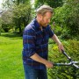 Mann schneidet Hecke mit Gardena Heckenschere 2in1 EnergyCut im Garten.