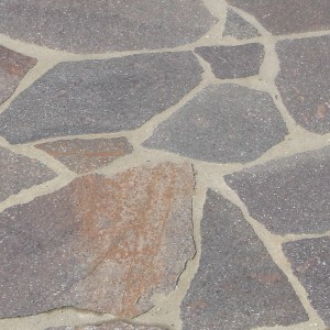 Mehrfarbige Porphyr-Polygonalplatten (20-40 mm) für Terrasse und Garten, verlegt mit hellen Fugen.