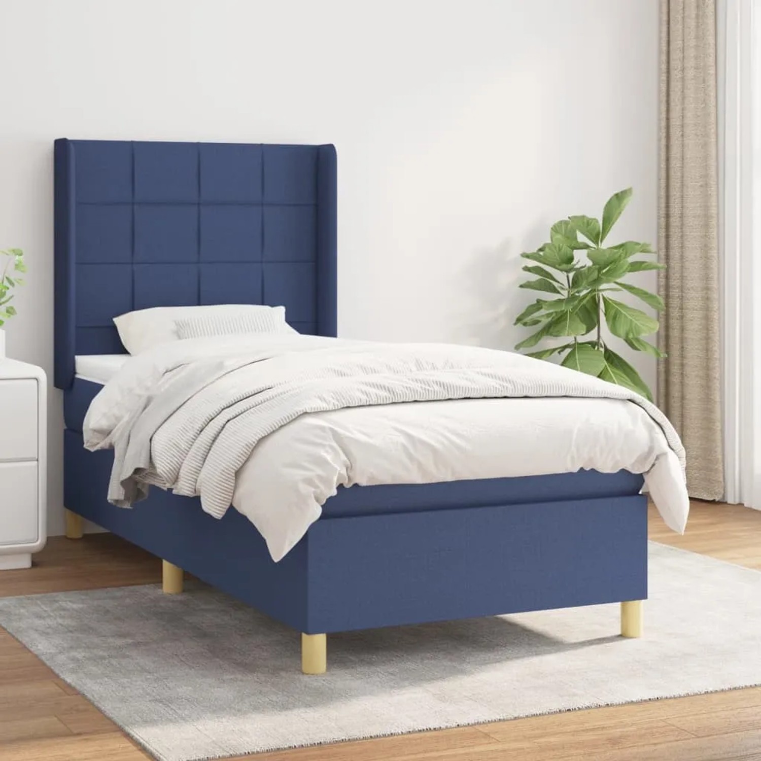 Blaues Boxspringbett (90x200 cm) mit Matratze und Stoffbezug. Bett mit hohem Kopfteil.