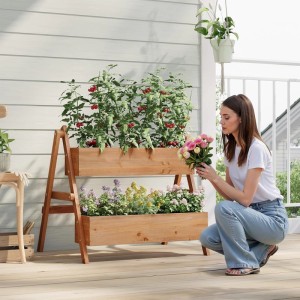 Braunes WOLTU Hochbeet mit 2 Blumenkästen aus Holz und Frau mit Blumenstrauß.