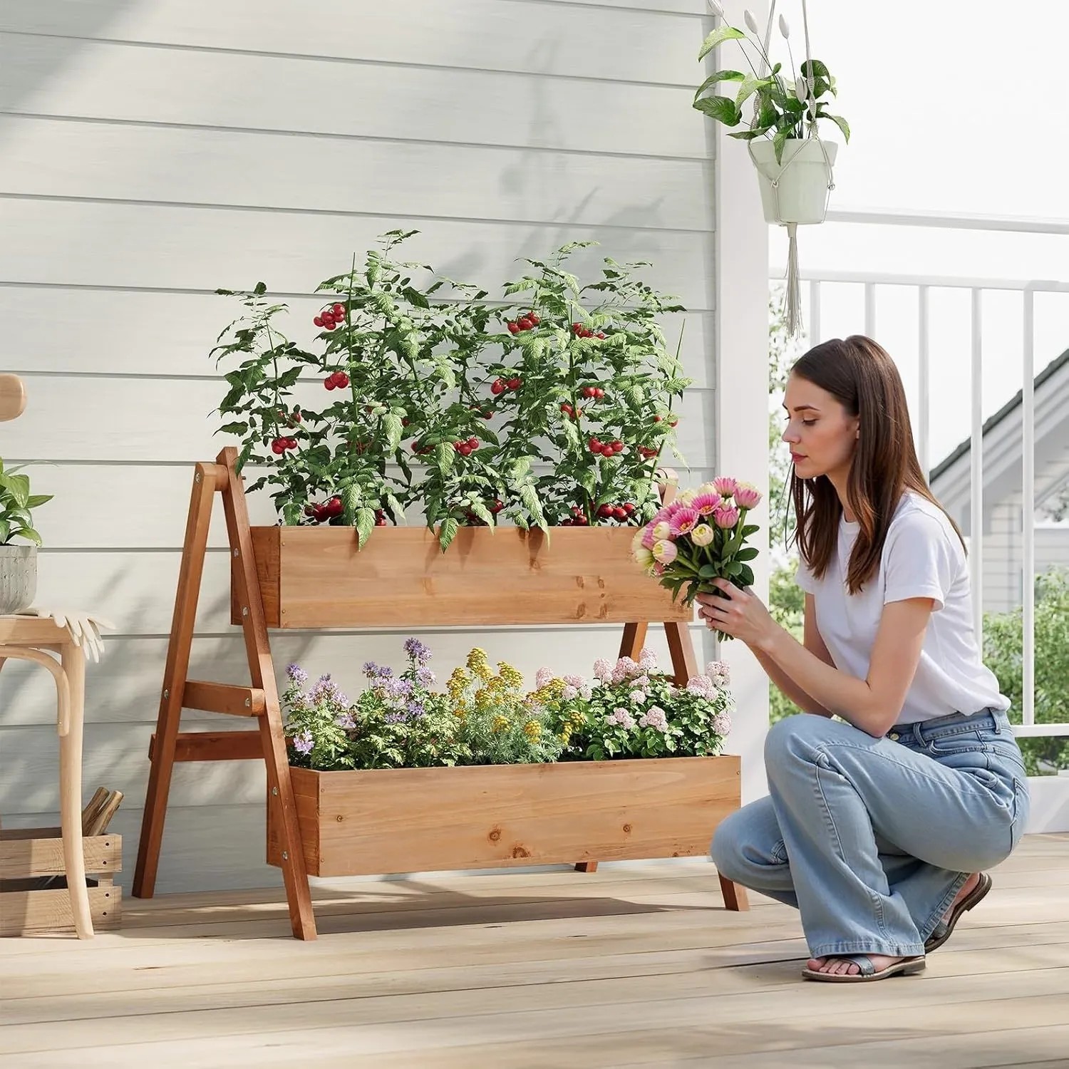 Braunes WOLTU Hochbeet mit 2 Blumenkästen aus Holz und Frau mit Blumenstrauß.