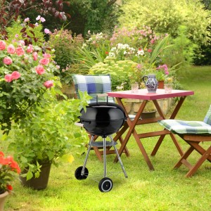 Schwarzer Relaxdays Kugelgrill mit Deckel und Rädern im Garten.