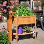 Braunes Dobar Hochbeet aus Holz mit Ablagefläche, bepflanzt mit Kräutern und Blumen.