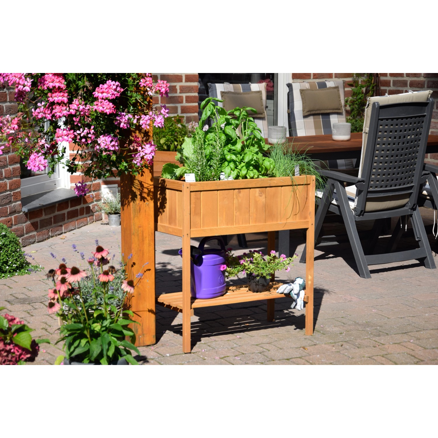 Braunes Dobar Hochbeet aus Holz mit Ablagefläche, bepflanzt mit Kräutern und Blumen.