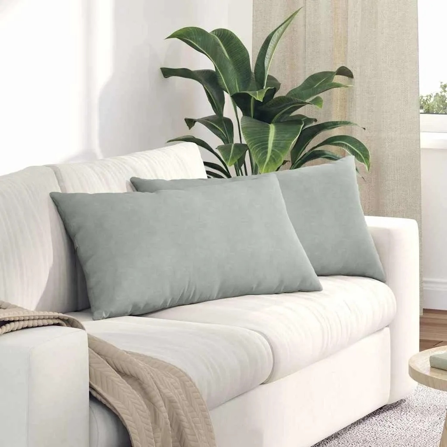 Zwei hellgraue Sofakissen aus Cordstoff auf weißem Sofa, 80x40 cm. Ideal für Wohnzimmer und Komfort.