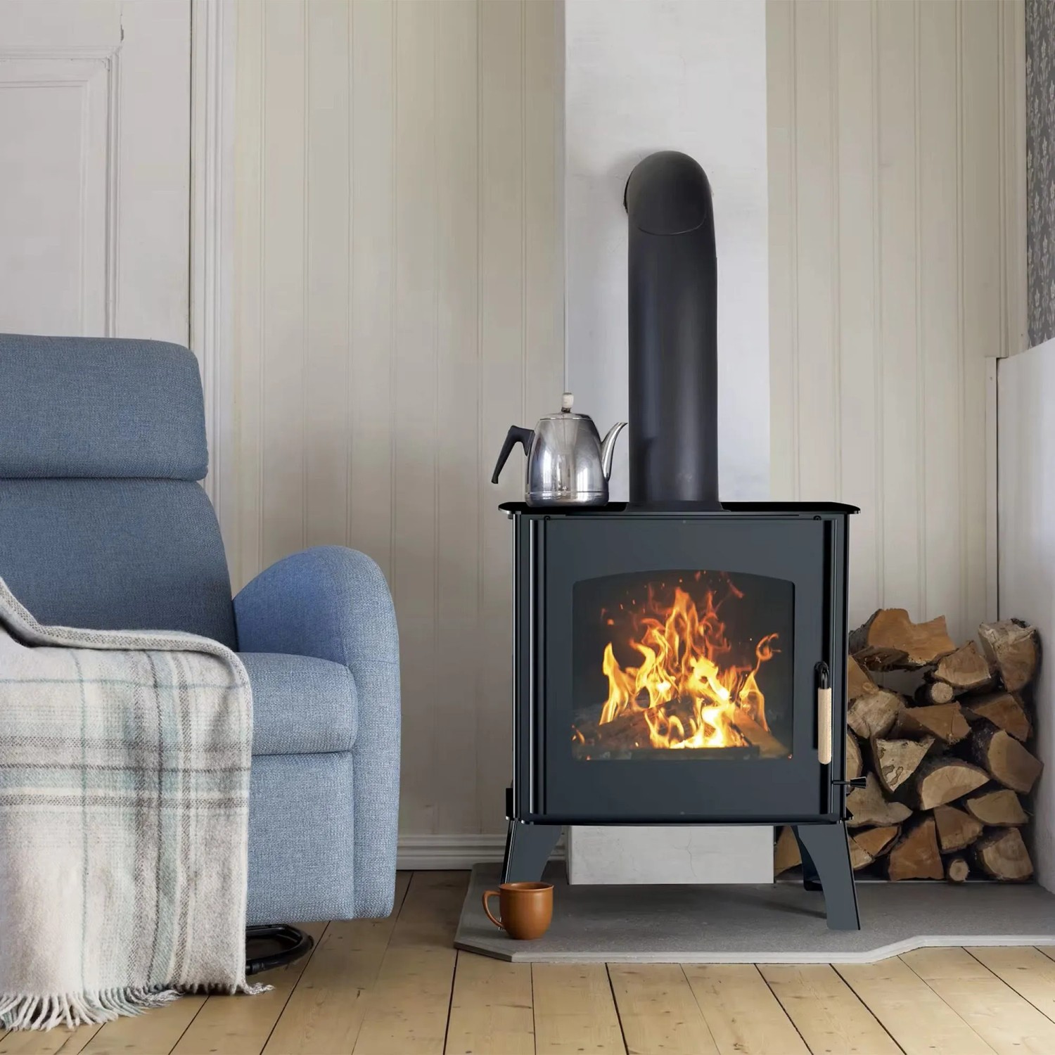 Sannover Holzofen Dita 11,8 kW mit Holzscheiten im Wohnraum. Kaminofen mit Feuer und Zubehör.