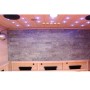 Innenansicht der Dewello Infrarotkabine Milton mit Steinwand, LED-Lichtern und Hemlock-Holz.