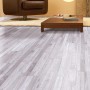 Heller Laminatboden im Pinie Sea Pine Dekor im Wohnraum mit Sessel und Tisch.