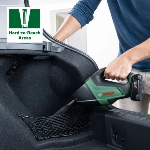Mann reinigt mit grünem Bosch Akku-Sauger UniversalVac 18V den Kofferraum eines Autos. Ideal für schwer erreichbare Stellen.