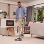 Mann saugt Teppich mit Ryobi Akku-Staubsauger RSVS18-0. Der Handstaubsauger mit LED-Licht für bessere Sicht.