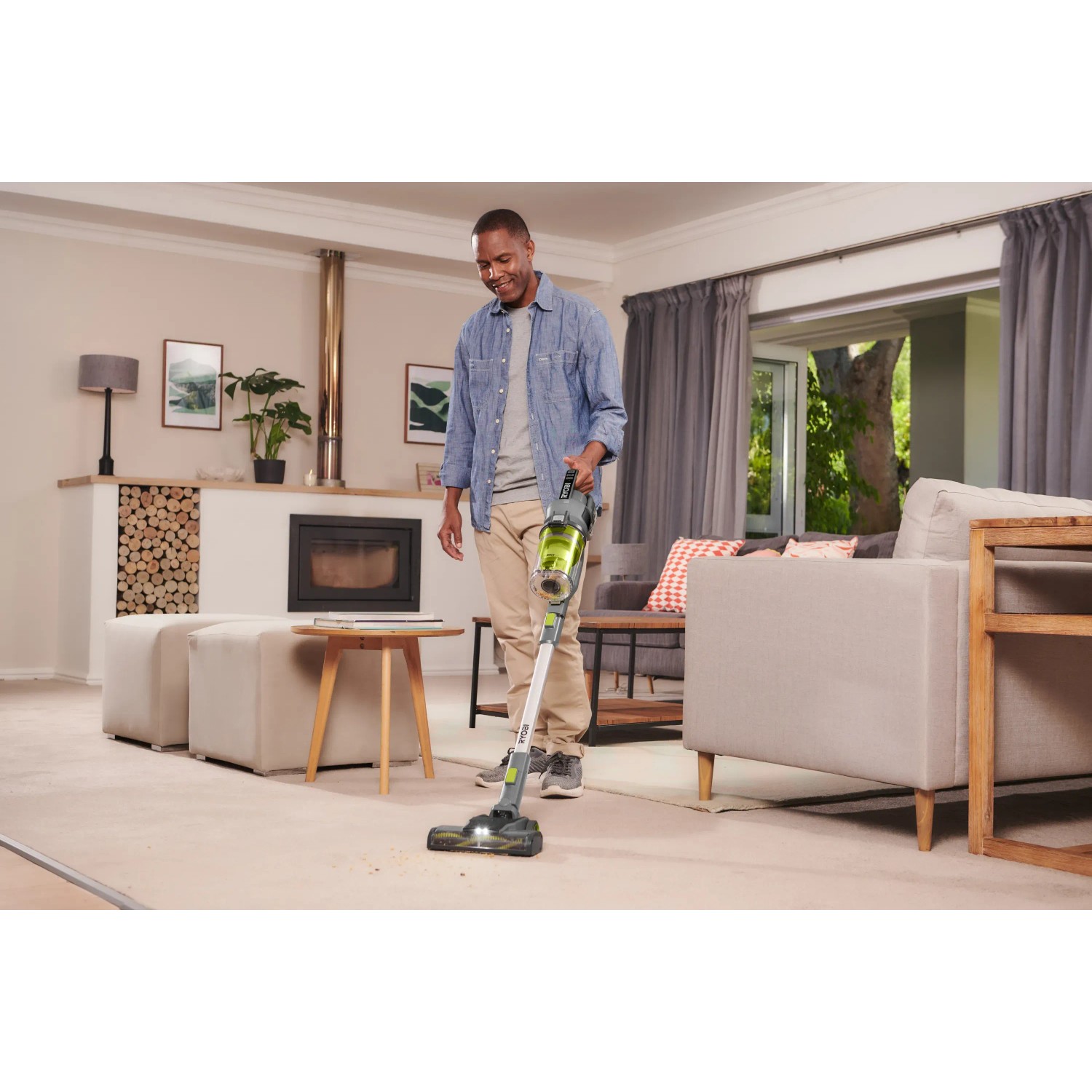 Mann saugt Teppich mit Ryobi Akku-Staubsauger RSVS18-0. Der Handstaubsauger mit LED-Licht für bessere Sicht.